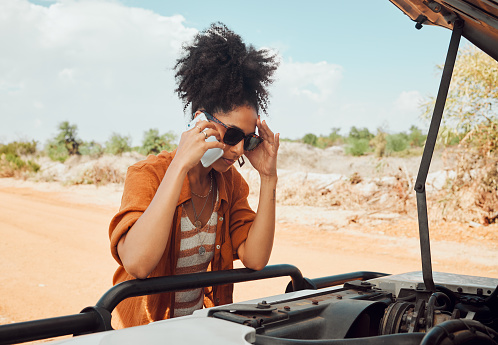 Worried woman, phone call and engine problems speaking to engineer or mechanic on a desert road in nature. Stressed black female calling roadside assistance on smartphone for mechanical issues