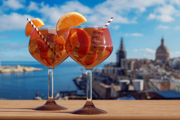 two glasses of spritz cocktail with view of valletta harbor and old town in valletta, malta. - ilhas de malta imagens e fotografias de stock