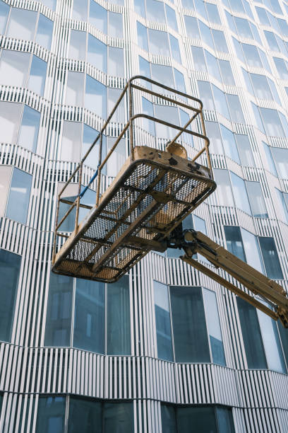 istock cherry picker to do maintenance work on a building facade. 1446086907