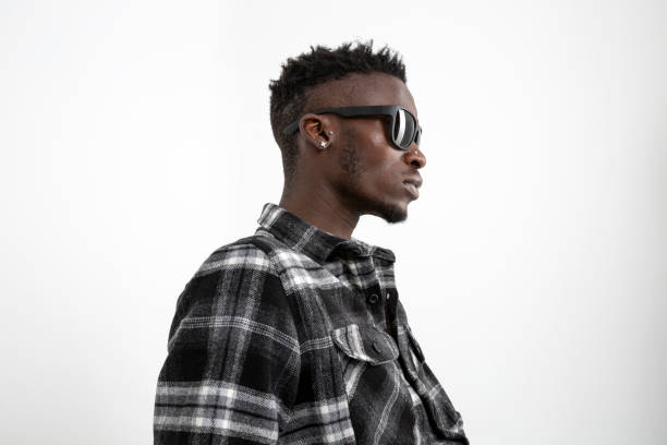 Black man wearing winter shirt against white background. Charismatic black photomodel with sunglasses.