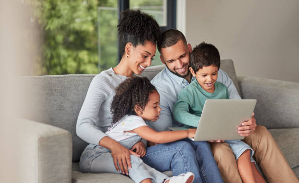 istock Laptop elearning and family on sofa or parents help with children education, support or watch cartoon show together. Relax mother, father and kids on couch on fun digital pc games or streaming online 1446089802