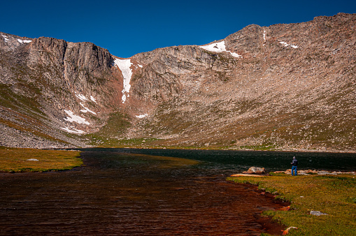 A beautiful blue sky over majestic mountains at Summit Lake on Mount Evans, Colorado being enjoyed by a photographer.