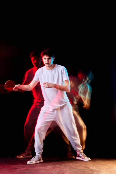 istock young man playing table tennis in mixed neon light 1446090384