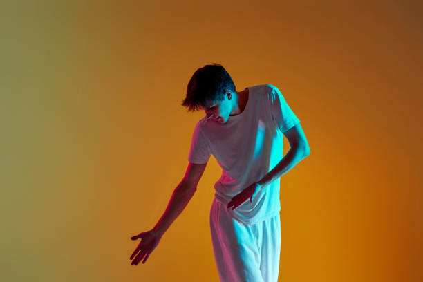 istock man dancing on yellow background. Neon lighting 1446091529