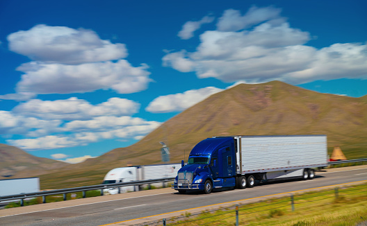 Blue semi-truck driving on a busy highway in Texas