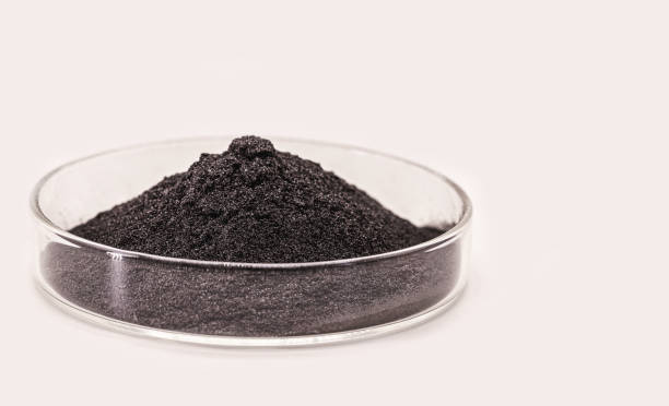 pigmento nero, polvere per uso industriale o cosmetico, fondo bianco isolato, in capsula di petri - oxide foto e immagini stock