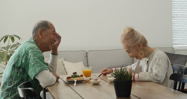 istock Laughing Senior Japanese Couple Eating Breakfast 1446094454