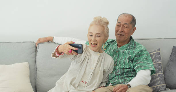 istock Cool Senior Japanese Couple Taking Selfie 1446094466