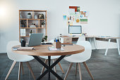 istock Empty office, laptop and documents in digital marketing space, advertising startup or creative small business. Furniture, technology and paper research in design workplace with table, desk and chairs 1446095706