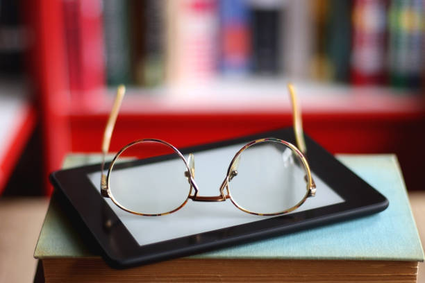 Stack of Books, E-Reader and Glasses stock photo