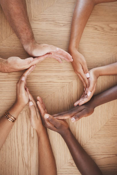 istock Diversity, teamwork and creative hands in synergy of employee workers together in collaboration at work. Table group of people hand in circle unity for agreement, help and team for community 1446097465