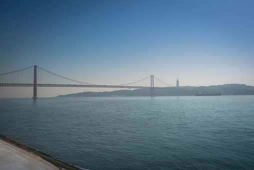 Tagus River (Rio Tejo) with 25 de Abril Bridge and Sanctuary of Christ the King on background  - Lisbon, Portugal