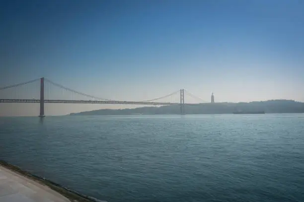Photo of Tagus River (Rio Tejo) with 25 de Abril Bridge and Sanctuary of Christ the King on background  - Lisbon, Portugal