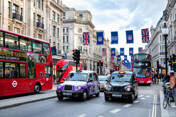 London, United Kingdom - October 10, 2016: A busy street scene with double decker buses, black taxi cabs traffic and crowd of pedestrians in Regent Street, London, England.