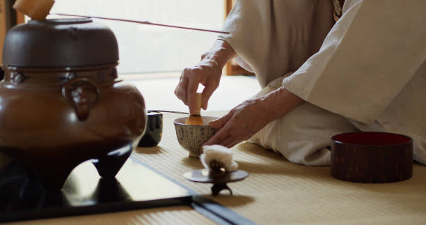 istock Host Whisking Tea at Traditional Japanese Tea Ceremony and Offering Bowl 1446100603
