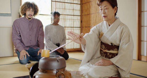 istock Attentive Guests Watching Hostess Prepare Tea at Traditional Tea Ceremony 1446100652