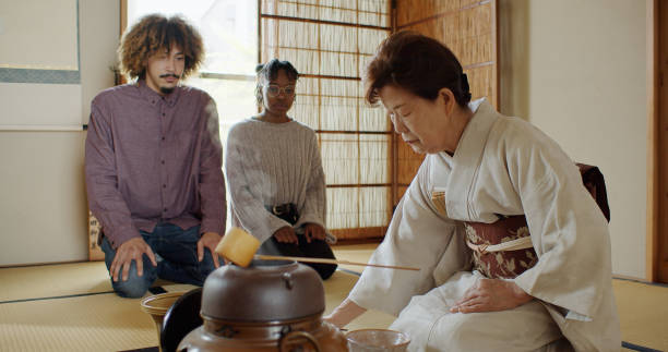 istock Guests Watching Hostess Whisk Tea at Traditional Japanese Ceremony 1446100653