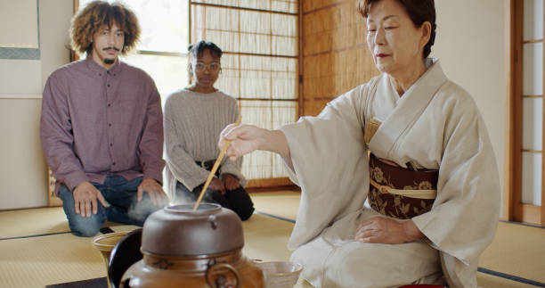 istock Guests Watching Hostess Preparing Tea at Traditional Japanese Ceremony 1446100659