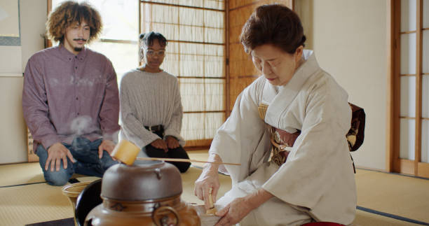 istock Guests Watching Hostess Whisk Tea at Traditional Japanese Ceremony 1446100662