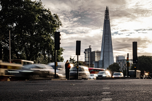 Lone person with Shard in the background amongst traffic