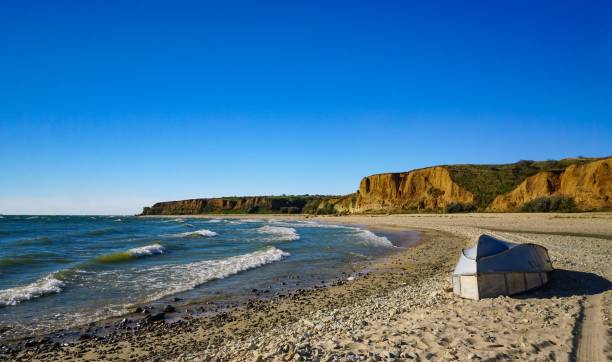istock Sandy beach, boat and steep banks on a sunny day 1446107513