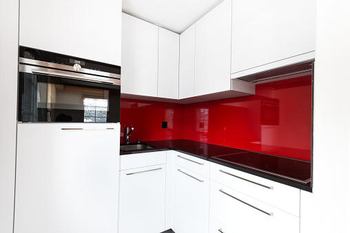 modern kitchen with red glass back wall and white fronts