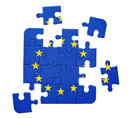EU flag printed on jigsaw puzzle in pieces.