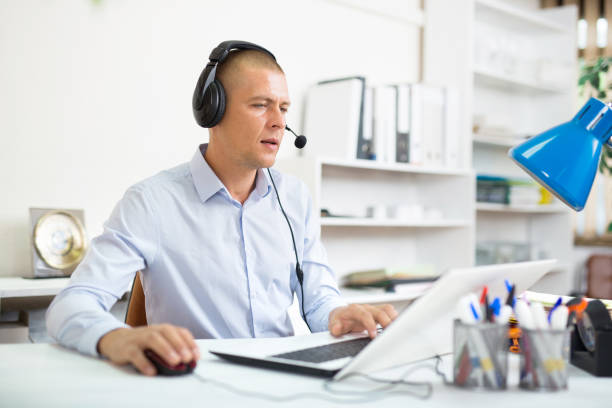 istock Man helpline operator with headphones during work in call center 1446109461