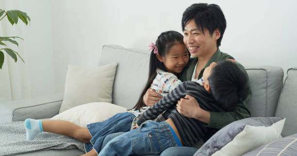 istock Japanese Family Cuddling on Couch 1446110450
