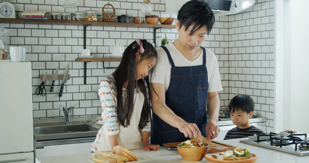 istock Kids Watching Dad Make Lunch in Modern Kitchen 1446110479