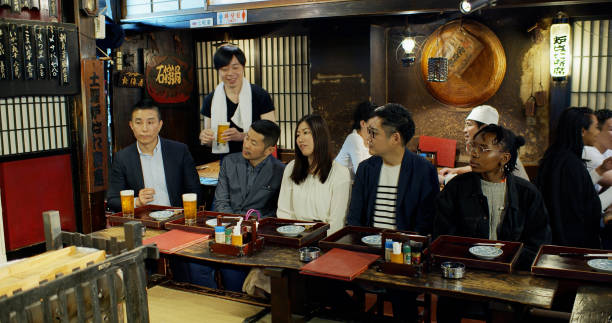 istock Waiter Carrying Beers Through Crowded Tokyo Restaurant 1446112599