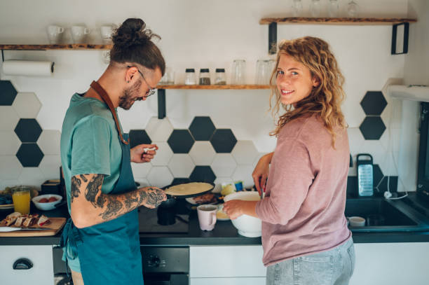 istock Young couple making breakfast together in the kitchen at home 1446112727