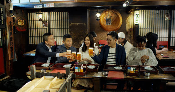 istock Friends Toasting Beers in Busy Tokyo Restaurant 1446112733