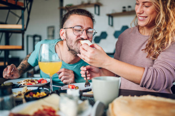istock Couple eating breakfast together while sitting at table at home 1446112734