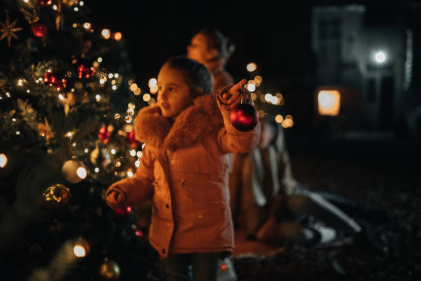 istock Young girl hanging Christmas ornaments 1446114980