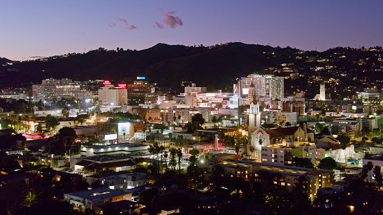 Aerial shot of Hollywood in Los Angeles, California at nightfall, looking across the cityscape towards the Hollywood Hills.