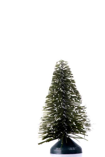 white light christmas card background with little ornament artificial christmas tree in the corner portrait