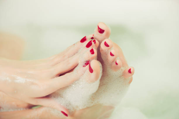 istock woman hands and feet covered with foam 1446117733