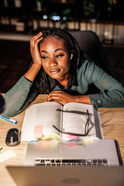 istock Tired studnet leaning against head against hand and taking a break from studying for exam 1446120405