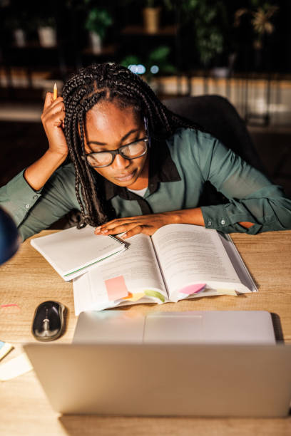 istock Tired university student leaning against her desk when studying for a long time late at night 1446120406