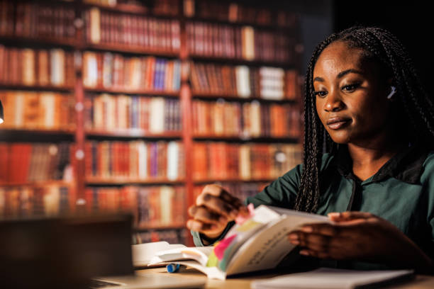 istock Young female student marking a book with sticky notes when studying 1446120430