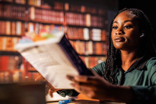 giovane donna che cerca un libro da studiare dopo quando si prepara per l'esame - guidebook foto e immagini stock