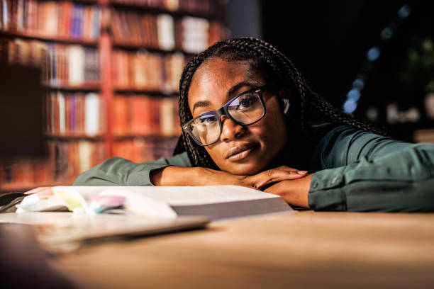 istock Tired university student leaning against her desk when studying for a long time late at night 1446120469