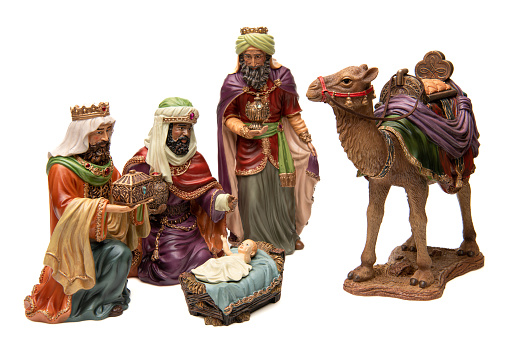 Adoration: Three wise men, camel, and baby Jesus figurines on white background