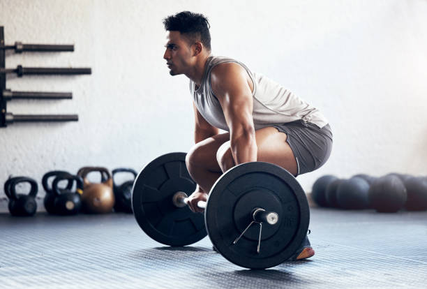 Workout, weightlifting and man doing deadlift training with strength, weights and motivation in fitness gym. Bodybuilder, sport and strong athlete doing power exercise with a dumbbell at health club