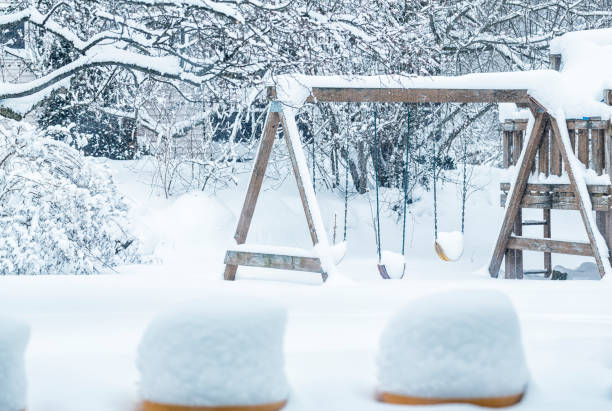 Back Yard Children's Swing Set Buried in Blizzard Snow stock photo