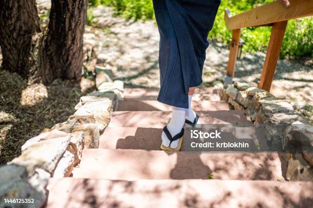 Feet Of Man In Kimono Costume Geta Tabi Shoes Socks In Outdoor Garden With Stone Steps Stairs In Japan By Wooden Railing Stock Photo - Download Image Now