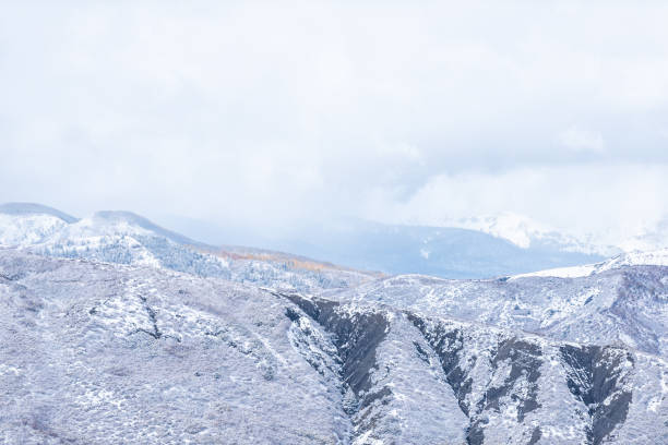 コロラド州アスペン ロッキー山脈 晩秋の山頂を覆う吹雪の高角ビューと、北米の轟音のフォークバレーの丘の中腹にある黄色い木の葉 - 24203 ストックフォトと画像