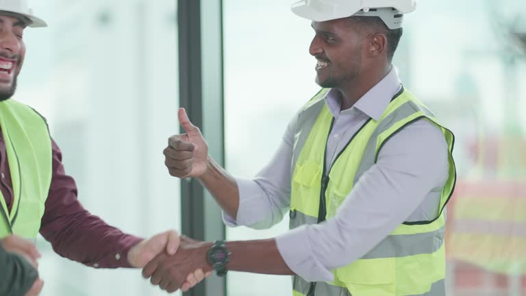 Diverse employees discuss, present work process in construction project or track the progress of the work done together. Multiracial worker or partnership in real estate business hand shake after meeting and business in office in central business district