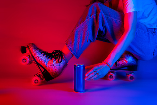Roller skater reaching for a soda drink in a can while skating. Sports and recreation - saturated red and blue, pop art style poster.
